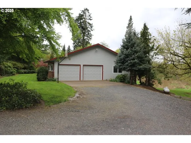 a view of a house with a yard and large tree