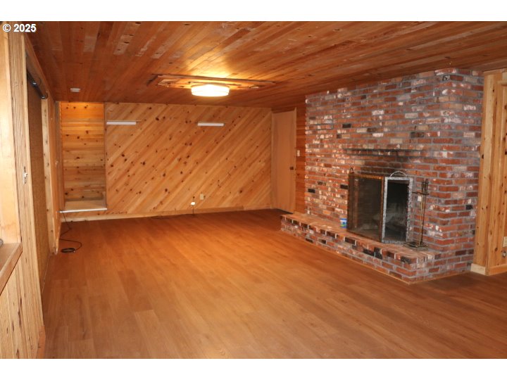 6503 Kinns Road Northeast Woodburn, OR 97071 - Photo 31 of 45 a view of an empty room with wooden floor and a fireplace