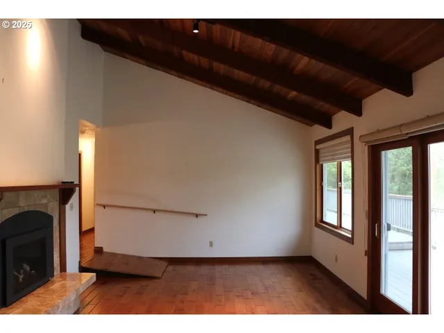 a view of an empty room with a fireplace and a window