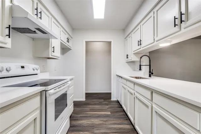 a kitchen with a sink stove and cabinets