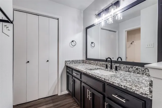 a bathroom with a granite countertop sink and a mirror