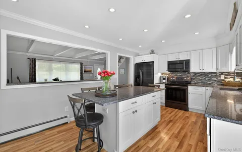 a kitchen with granite countertop appliances a sink and cabinets