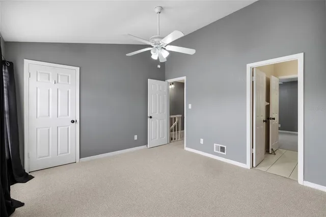 a view of an empty room with closet and a chandelier fan