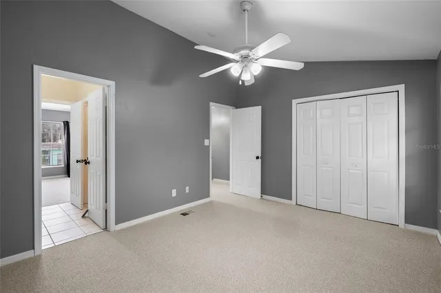 an empty room with fan closet and fan