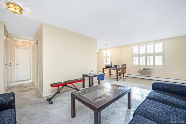 a living room with furniture a flat screen tv and a window