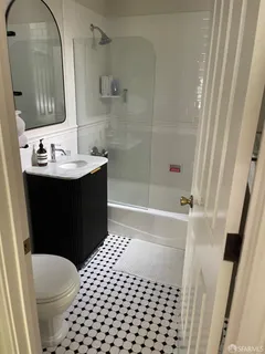 a bathroom with a sink a toilet a mirror and shower
