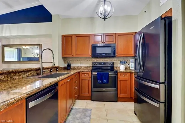 a kitchen with stainless steel appliances granite countertop a stove refrigerator and microwave