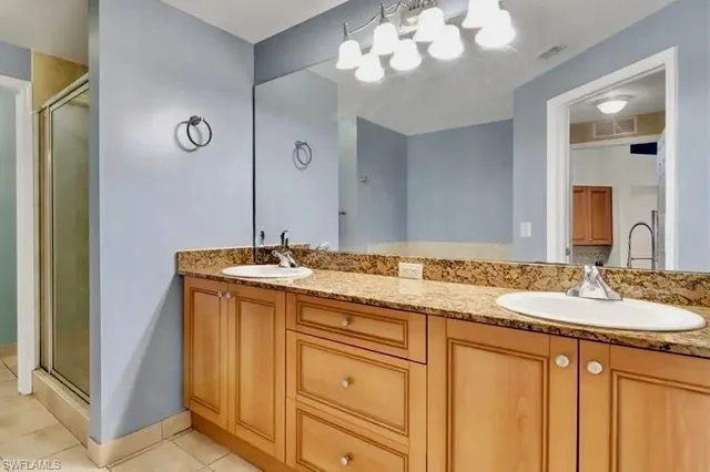 a bathroom with a granite countertop sink a large mirror and a shower