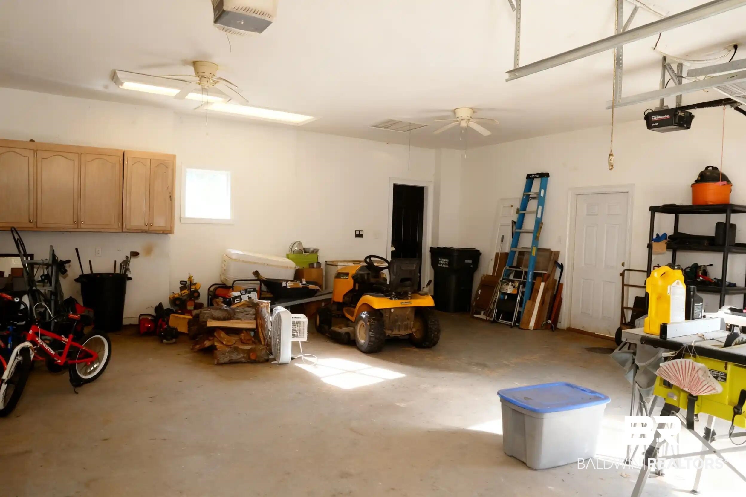 8008 Patricks Landing Road Bay Minette, AL 36507 - Photo 17 of 33 Spacious garage featuring a concrete floor, overhead fluorescent lighting, and two ceiling fans