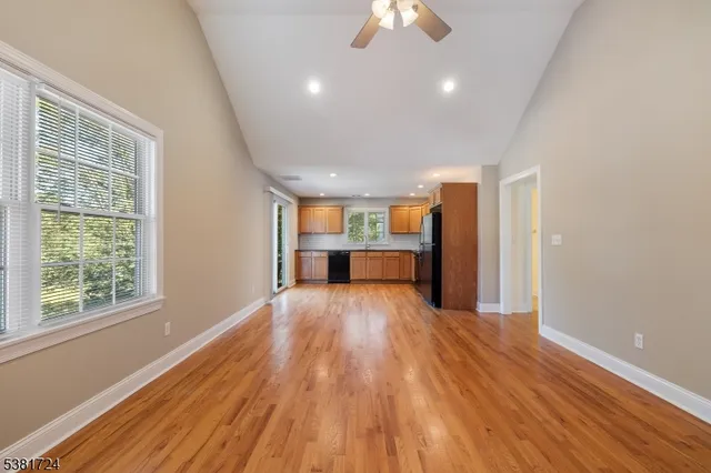 a view of empty room with wooden floor and window