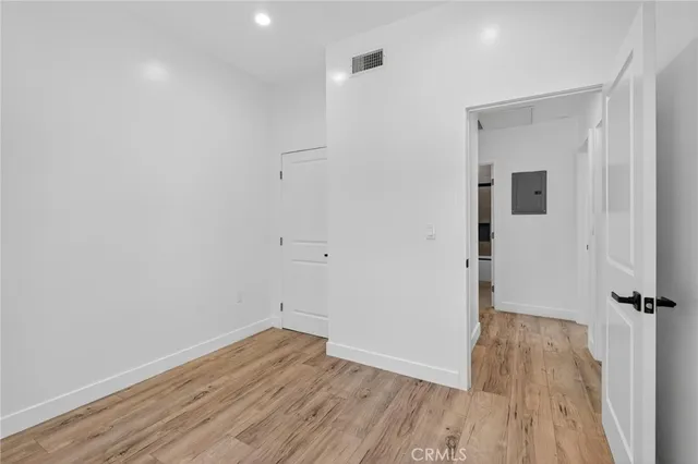an empty room with wooden floor and window