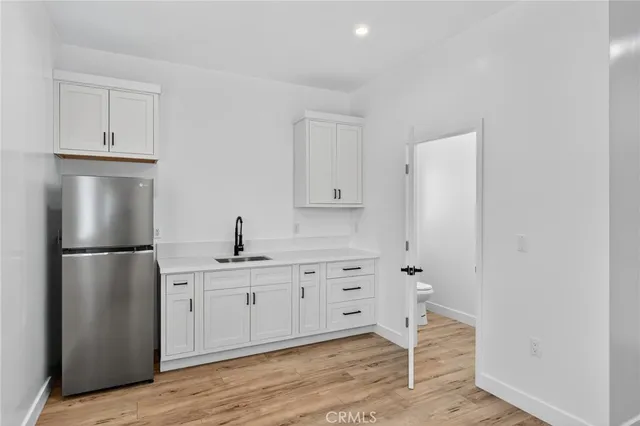 a view of a kitchen with wooden floor and a sink