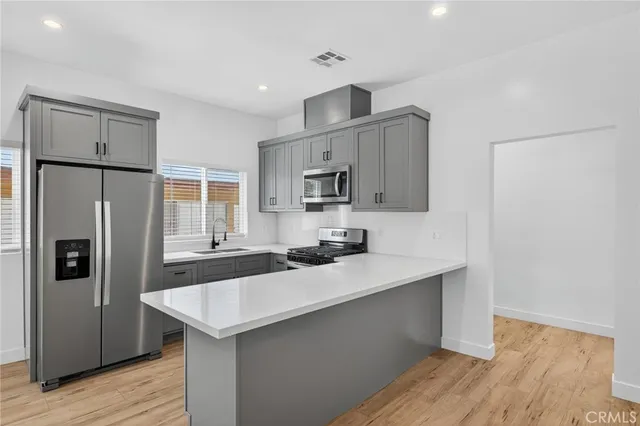 a kitchen with granite countertop white cabinets and black stainless steel appliances