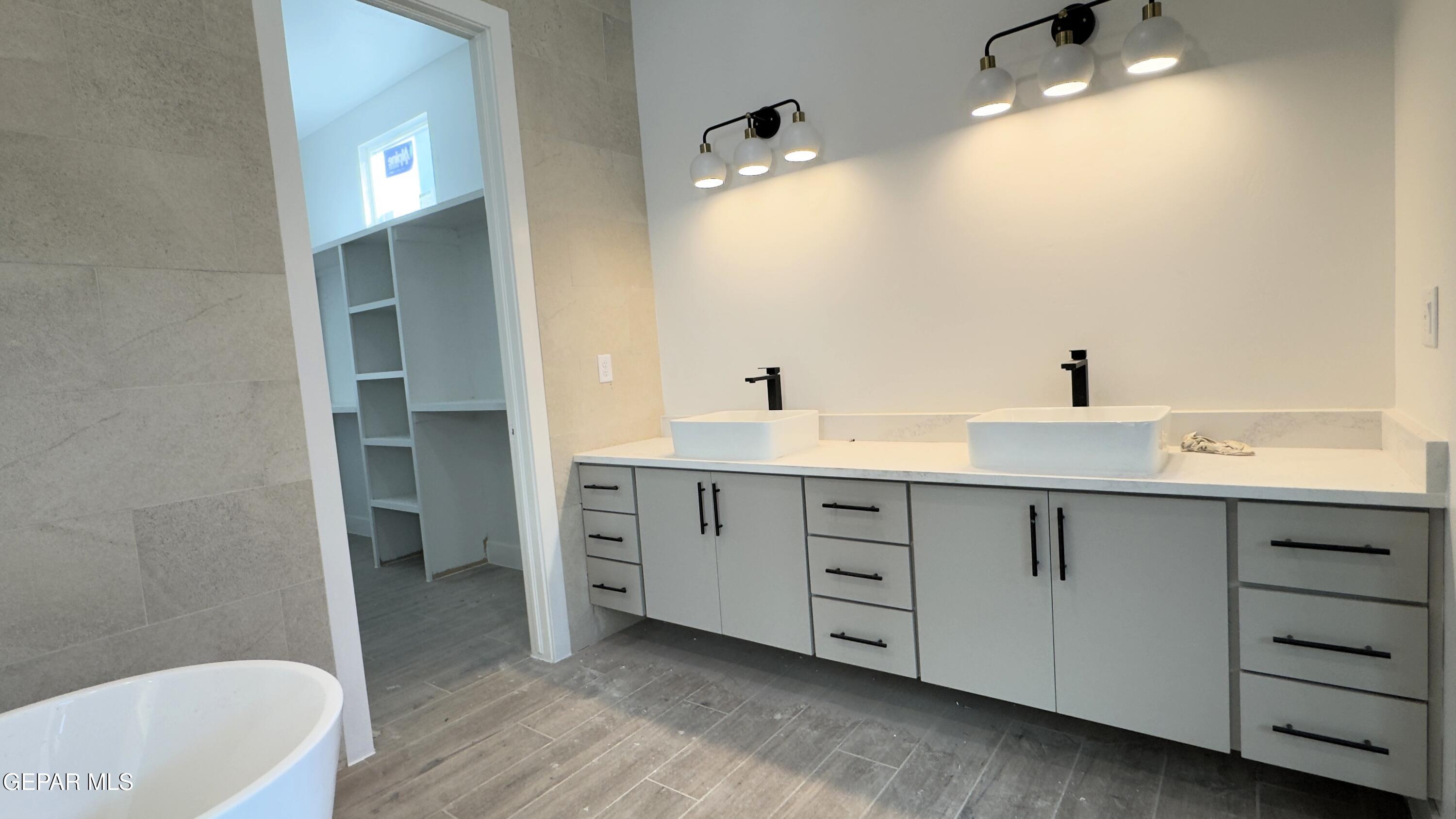 5656 Rio Bonito Circle El Paso, TX 79932 - Photo 20 of 36 a spacious bathroom with a double vanity sink a large mirror and a bathtub