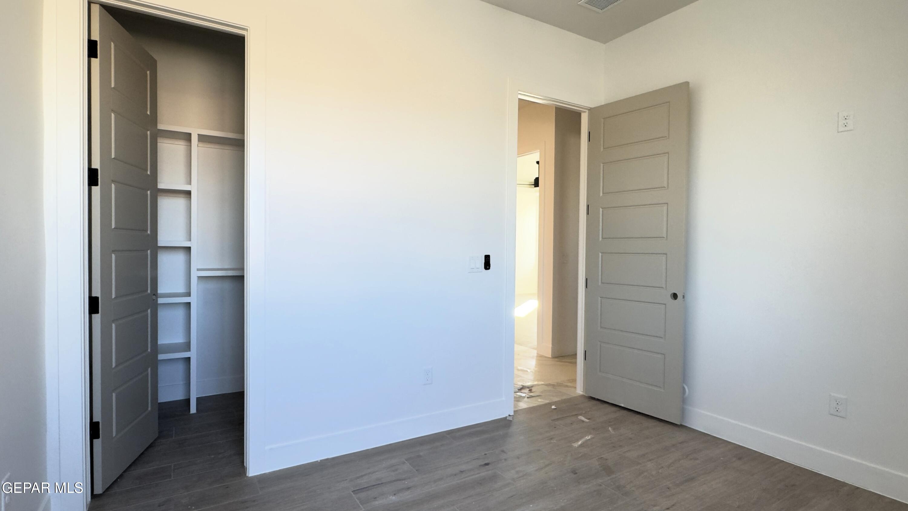 5656 Rio Bonito Circle El Paso, TX 79932 - Photo 27 of 36 a view of an empty room with closet and wooden floor