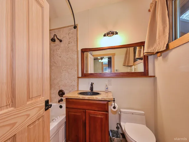 a bathroom with a granite countertop sink toilet and shower