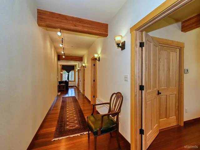 a view of a hallway with wooden floor and staircase