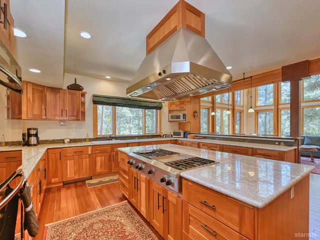 a kitchen with stainless steel appliances granite countertop a sink stove and cabinets