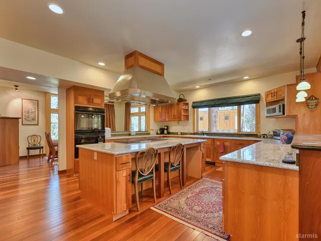 a kitchen with stainless steel appliances granite countertop sink stove top oven and cabinets
