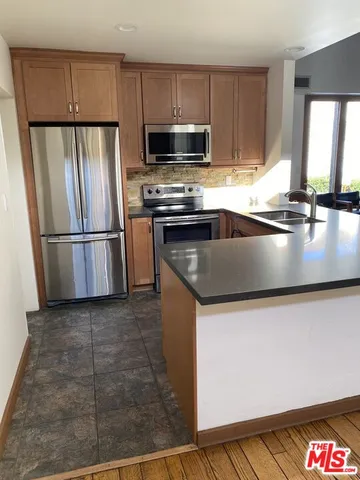 a kitchen with granite countertop a refrigerator and a sink