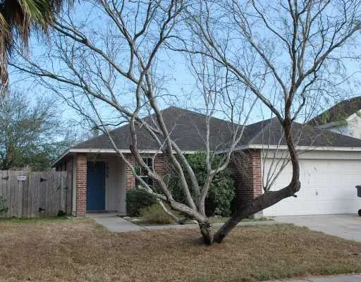 a view of a house with a wooden fence and a large tree