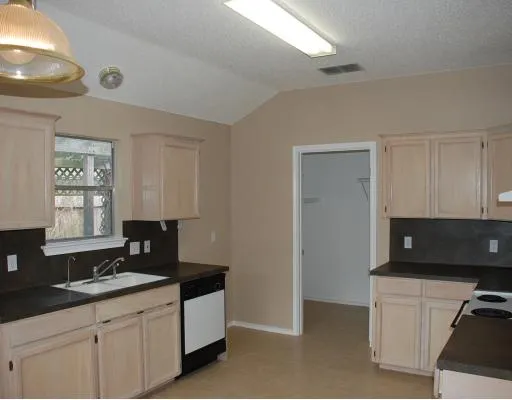 a kitchen with granite countertop white cabinets and black appliances