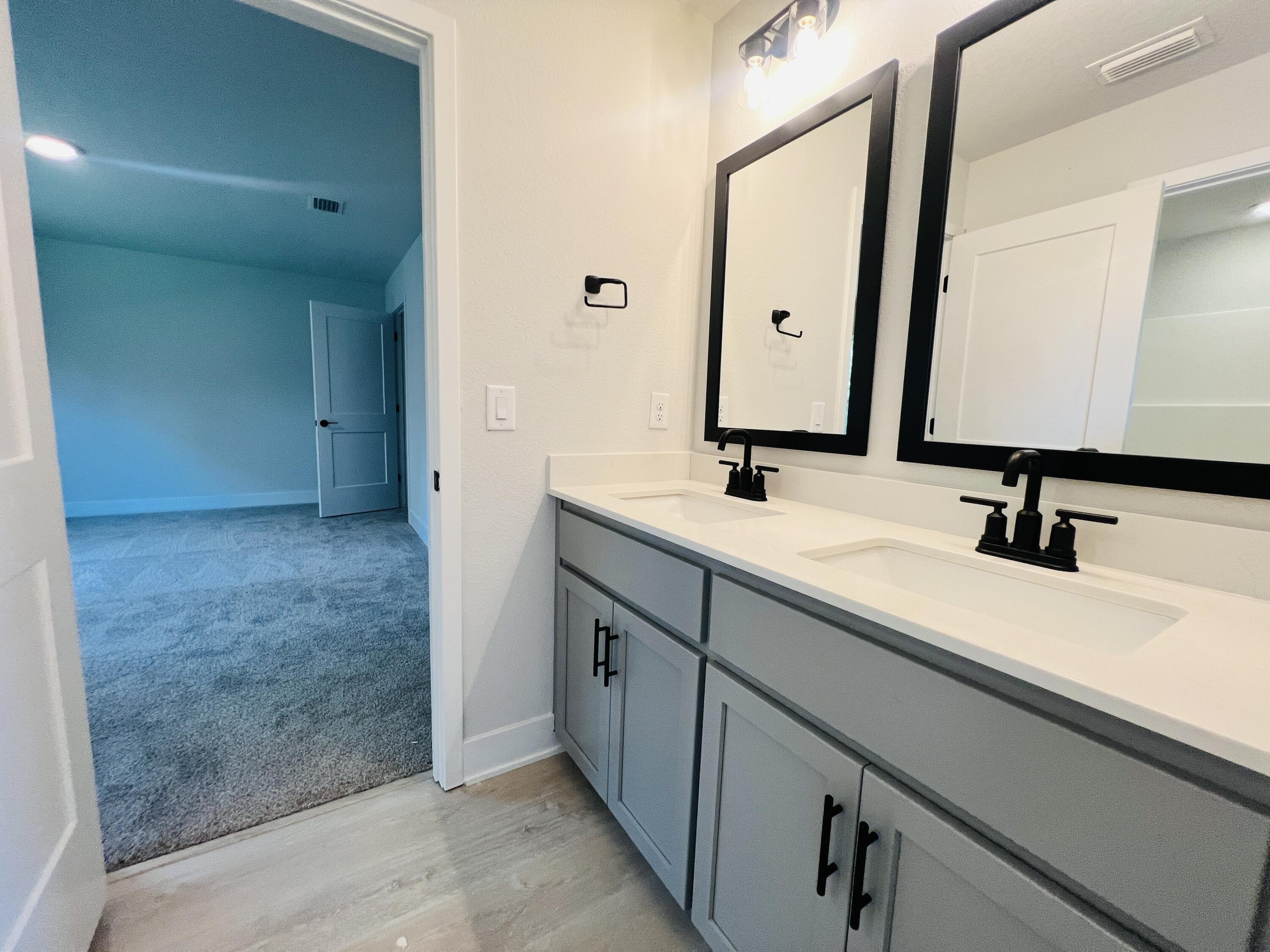 5303 Hidden Pines Circle Milton, FL 32583 - Photo 20 of 22 a bathroom with a double vanity sink a mirror and a bathtub