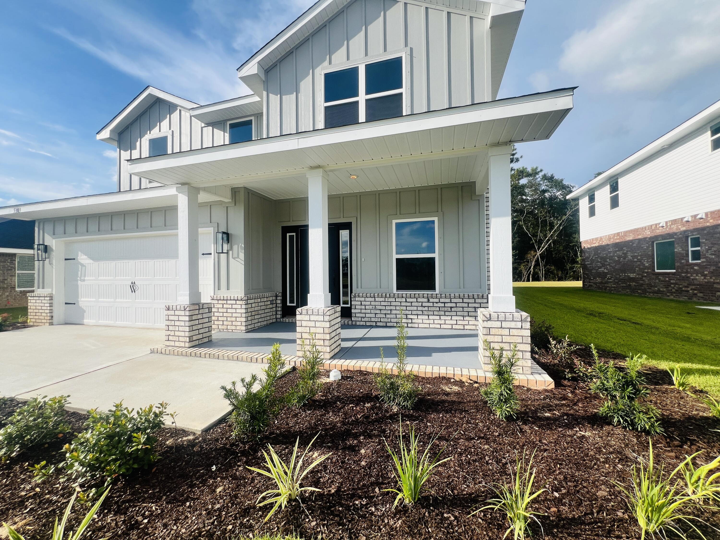 5303 Hidden Pines Circle Milton, FL 32583 - Photo 3 of 22 a front view of a house with garden