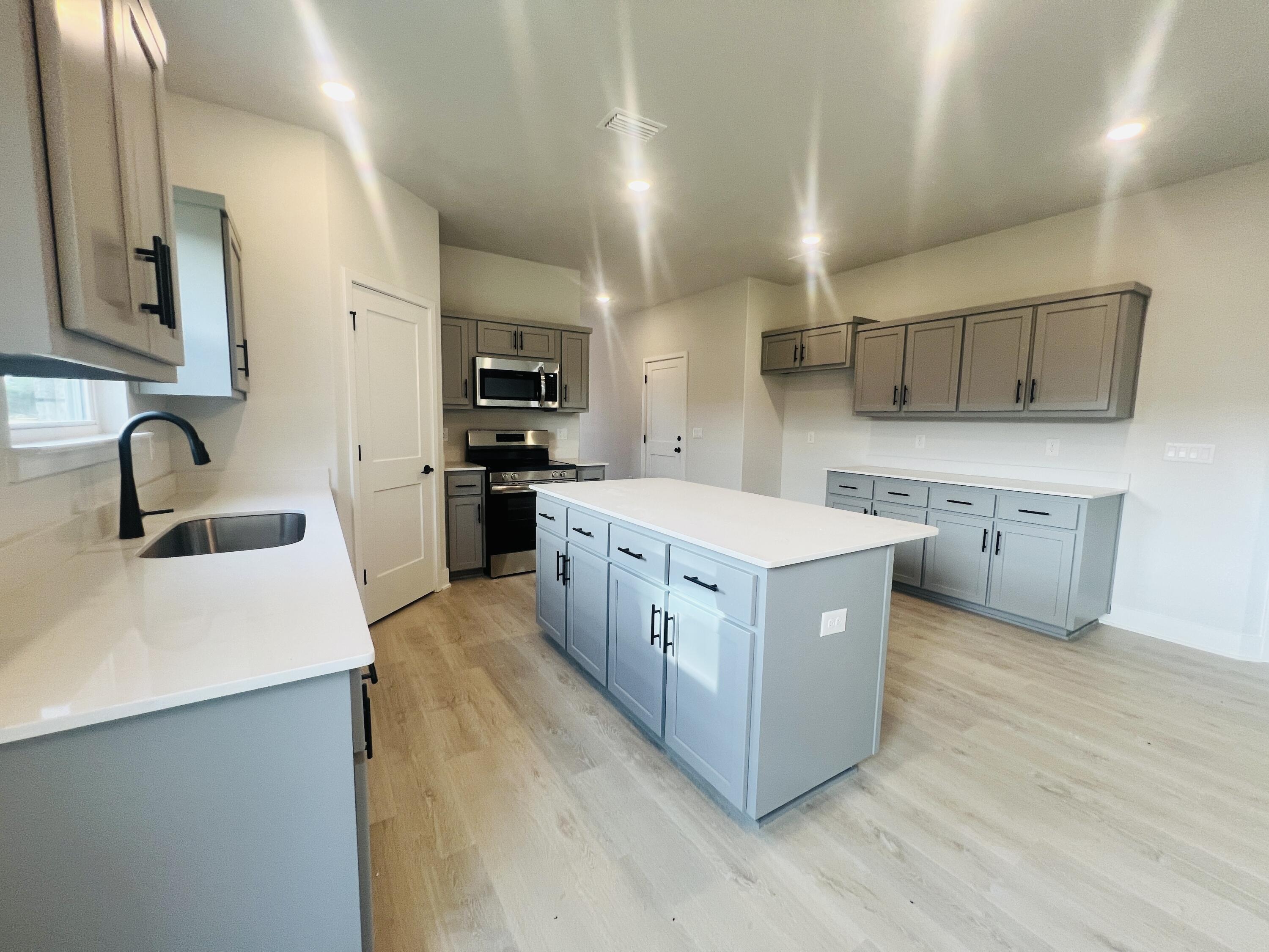 5303 Hidden Pines Circle Milton, FL 32583 - Photo 7 of 22 a large kitchen with stainless steel appliances sink a stove and cabinets