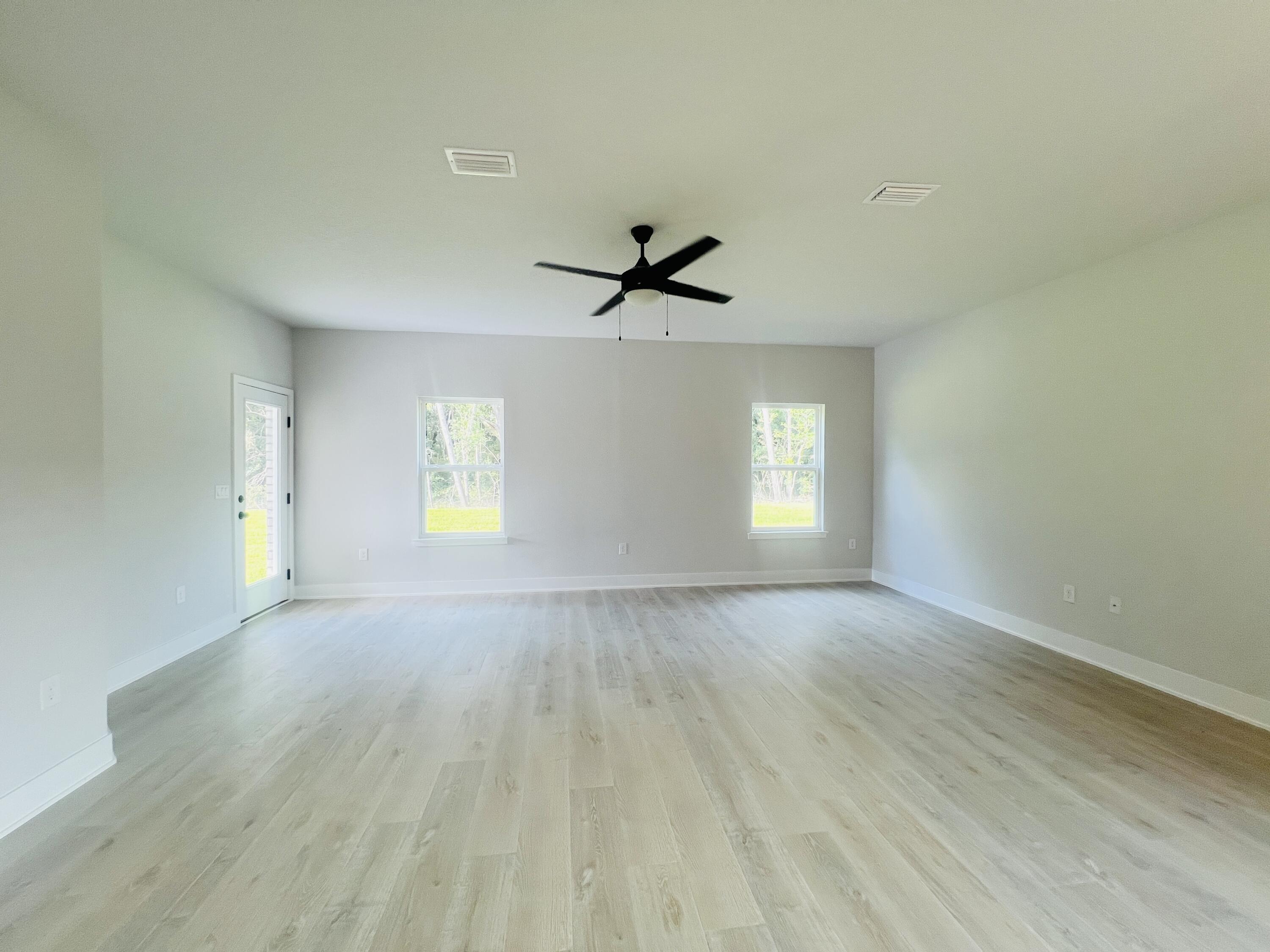 5303 Hidden Pines Circle Milton, FL 32583 - Photo 9 of 22 wooden floor in an empty room with a window