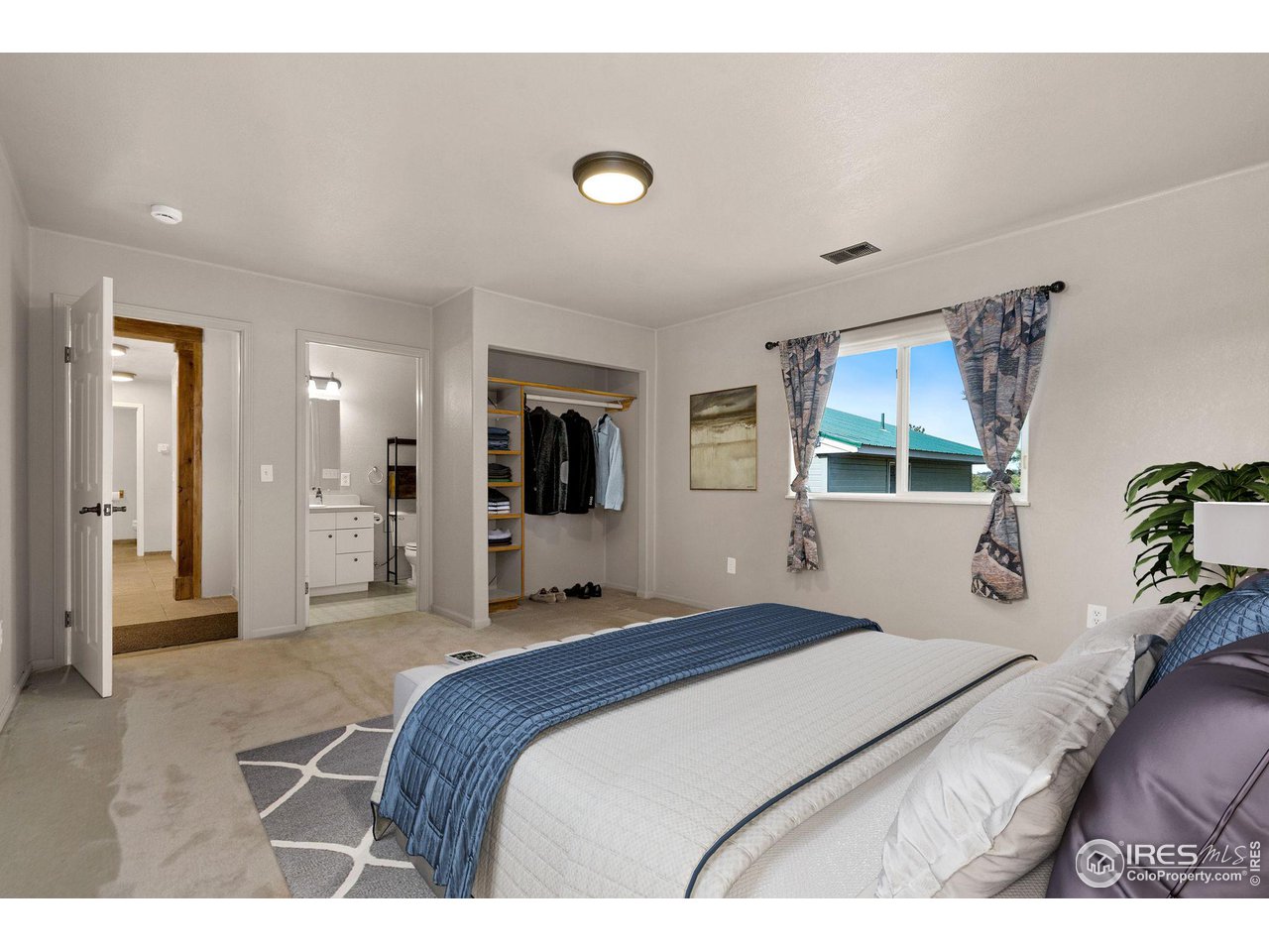 7770 Red Mountain Road Livermore, CO 80536 - Photo 18 of 36 a bedroom with a bed and a flat screen tv