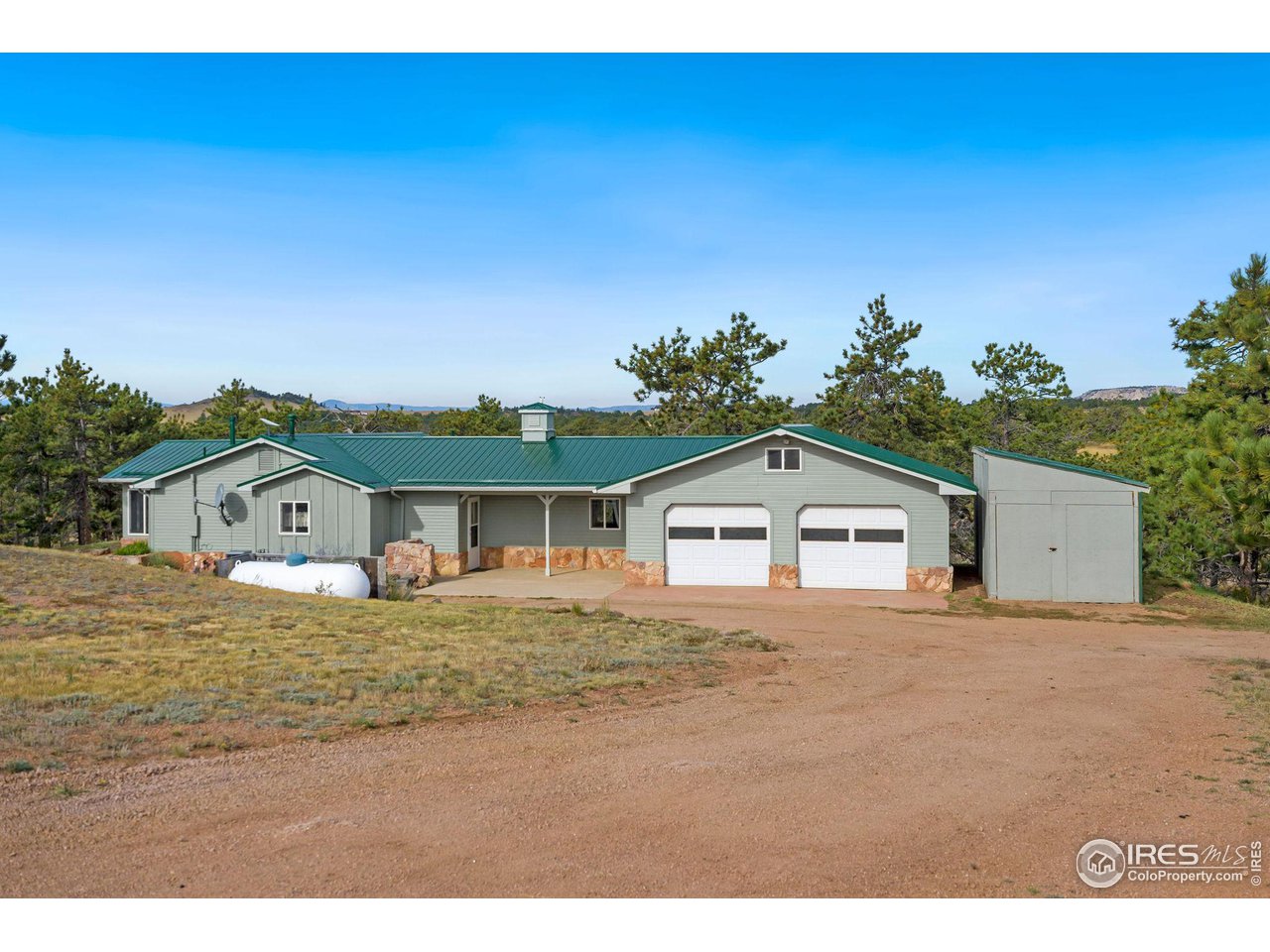 7770 Red Mountain Road Livermore, CO 80536 - Photo 21 of 36 a big house with a big yard and large trees