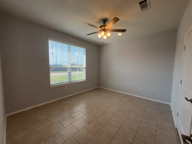 an empty room with windows and fan
