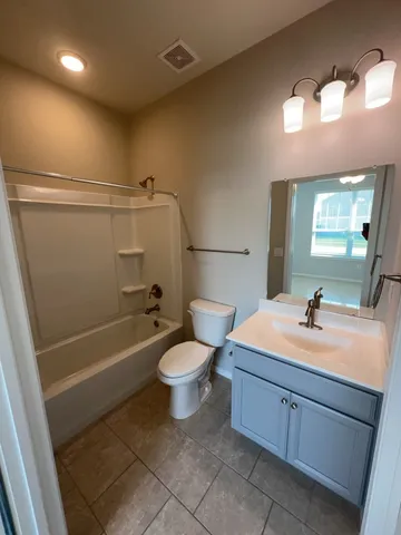 a bathroom with a sink a toilet a mirror and bathtub