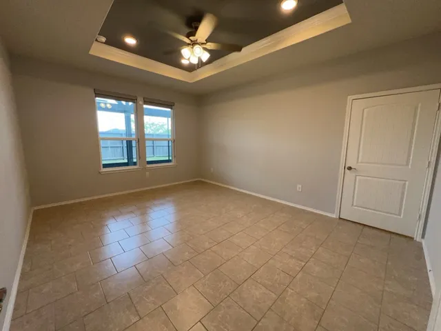 an empty room with windows and ceiling fan