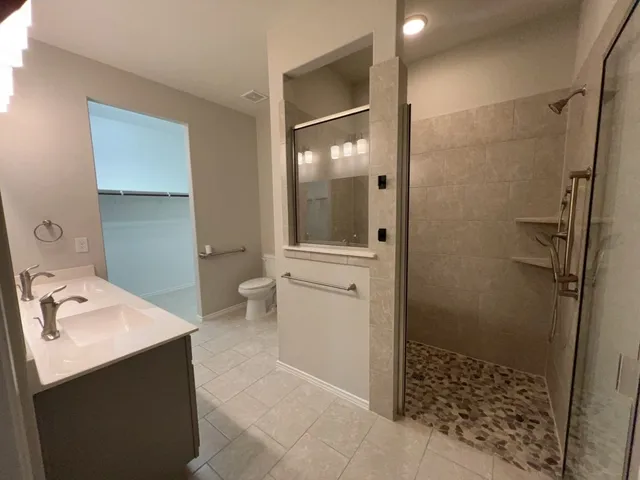 a bathroom with a sink a toilet and shower