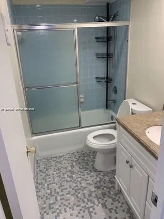 a bathroom with a granite countertop toilet a sink and shower