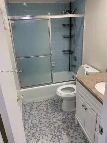 a bathroom with a granite countertop toilet a sink and shower