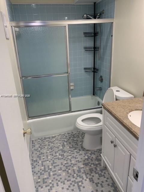 632 Northwest 13th Street, Unit 230 Boca Raton, FL 33486 - Photo 11 of 12 a bathroom with a granite countertop toilet a sink and shower