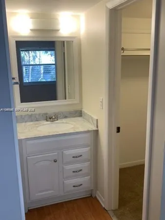 a bathroom with a granite countertop sink and mirror