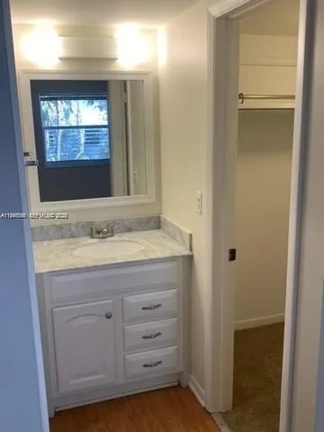 a bathroom with a granite countertop sink and mirror
