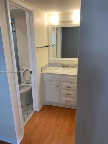a bathroom with a sink a toilet and a mirror