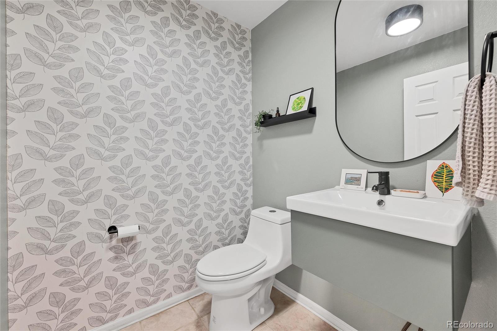 893 South Evanston Circle Aurora, CO 80012 - Photo 13 of 28 a bathroom with a toilet sink and mirror