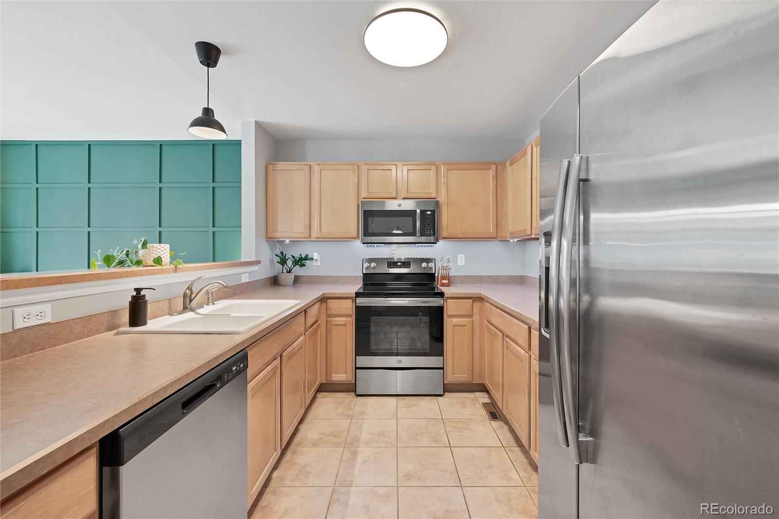 893 South Evanston Circle Aurora, CO 80012 - Photo 9 of 28 a kitchen with a sink stove and refrigerator