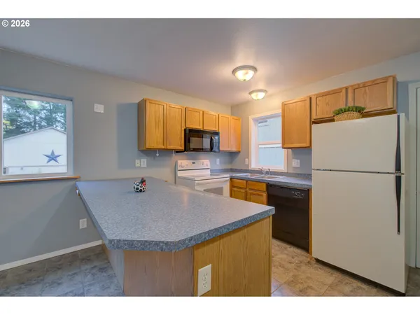 a kitchen with kitchen island a refrigerator a stove a microwave a sink and a dining table