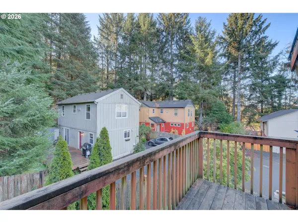 a view of a wooden fence and trees in the balcony