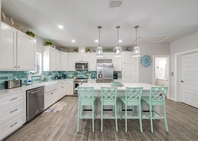 a large kitchen with kitchen island a dining table and chairs