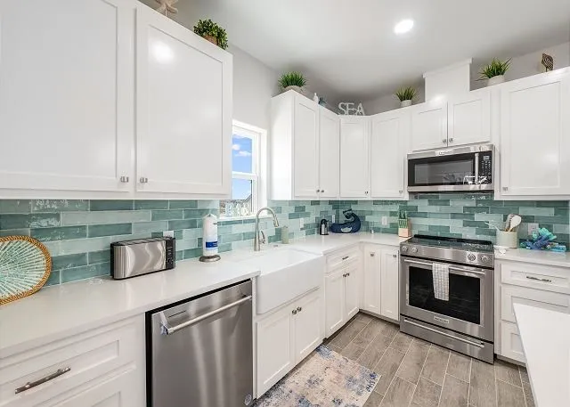 a kitchen with stainless steel appliances granite countertop a sink and a stove
