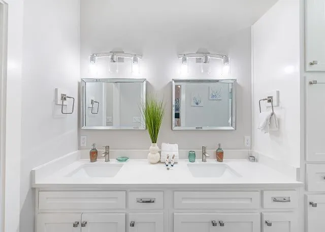 a bathroom with double vanity sinks and a mirror