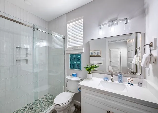 a bathroom with a sink toilet a mirror and shower
